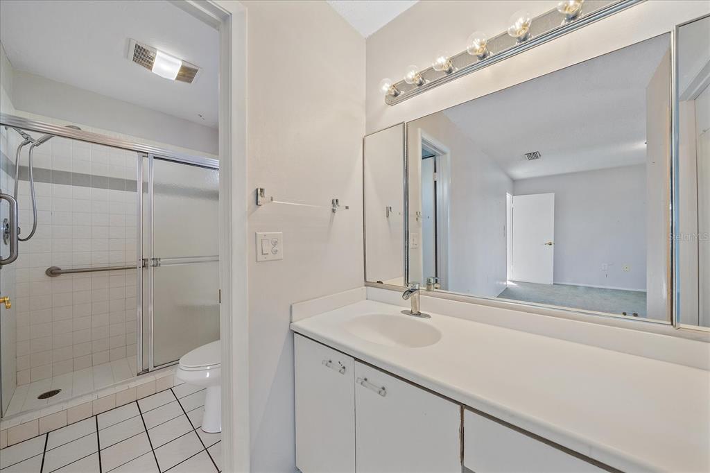 6157 Midnight Pass Road, Unit B12 Sarasota, FL 34242 - Photo 32 of 75 a bathroom with a shower sink and mirror