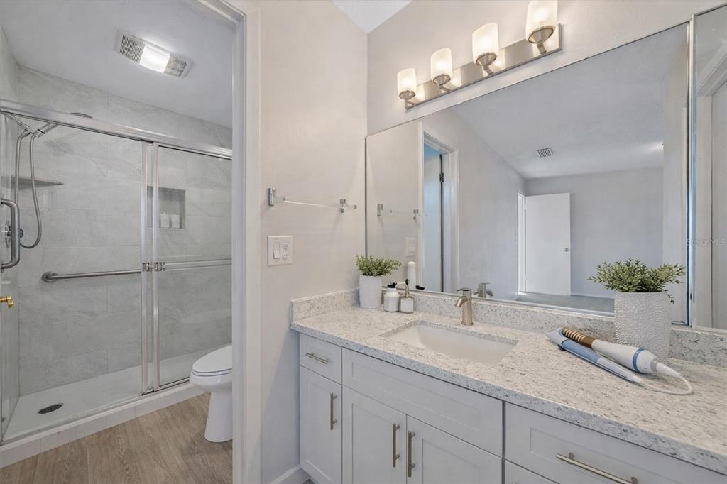 6157 Midnight Pass Road, Unit B12 Sarasota, FL 34242 - Photo 33 of 75 a bathroom with a granite countertop sink a toilet and shower