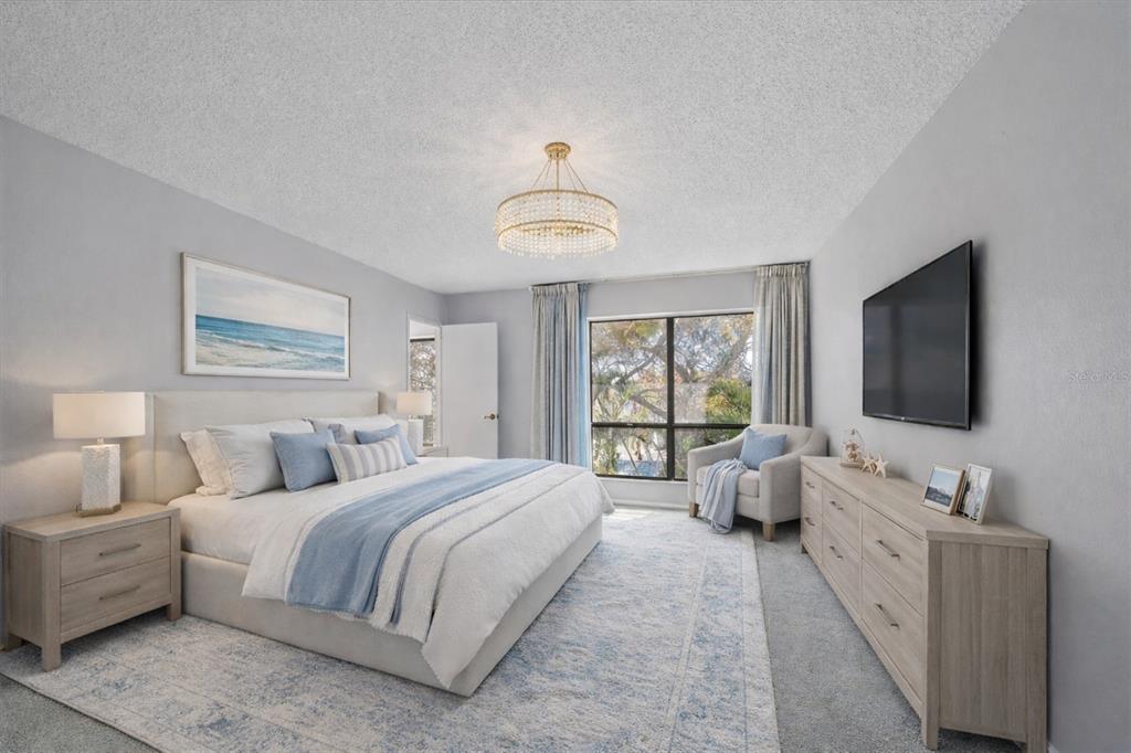 6157 Midnight Pass Road, Unit B12 Sarasota, FL 34242 - Photo 43 of 75 a spacious bedroom with a bed and a flat screen tv