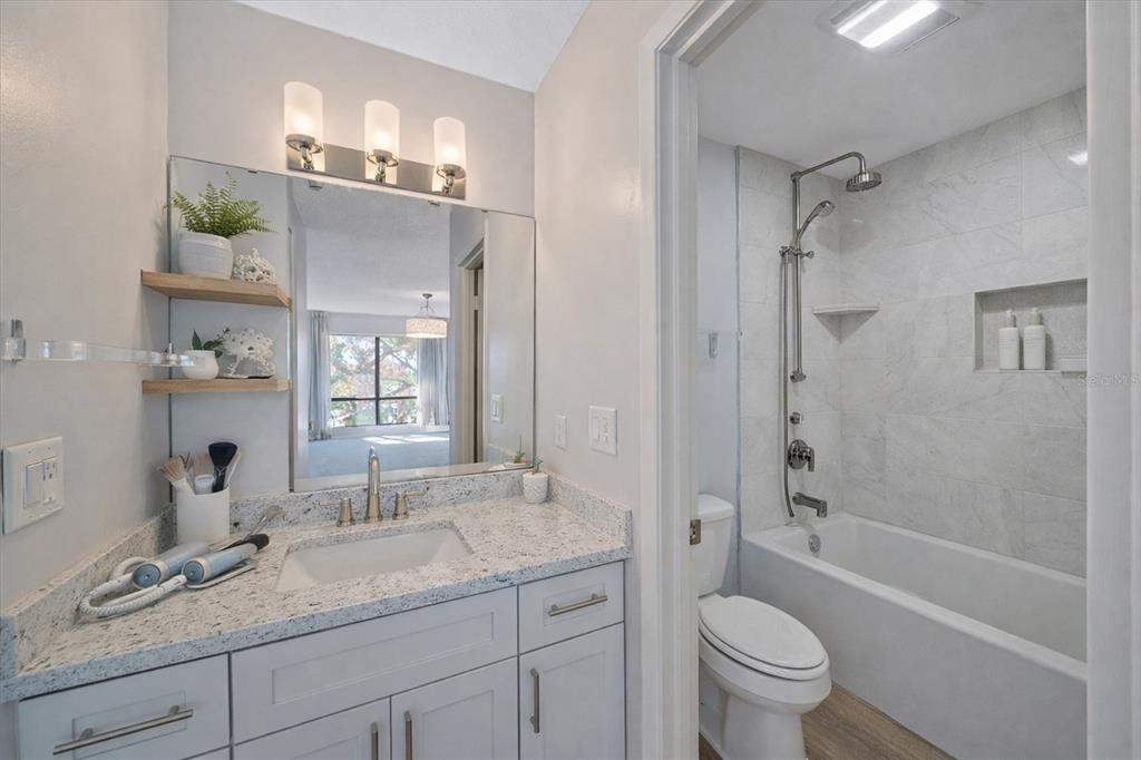 6157 Midnight Pass Road, Unit B12 Sarasota, FL 34242 - Photo 45 of 75 a bathroom with a granite countertop sink a toilet and bathtub