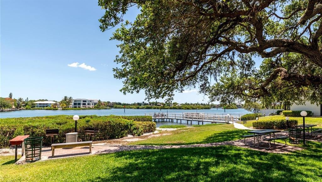 6157 Midnight Pass Road, Unit B12 Sarasota, FL 34242 - Photo 53 of 75 a view of a swimming pool and lounge chairs in the patio