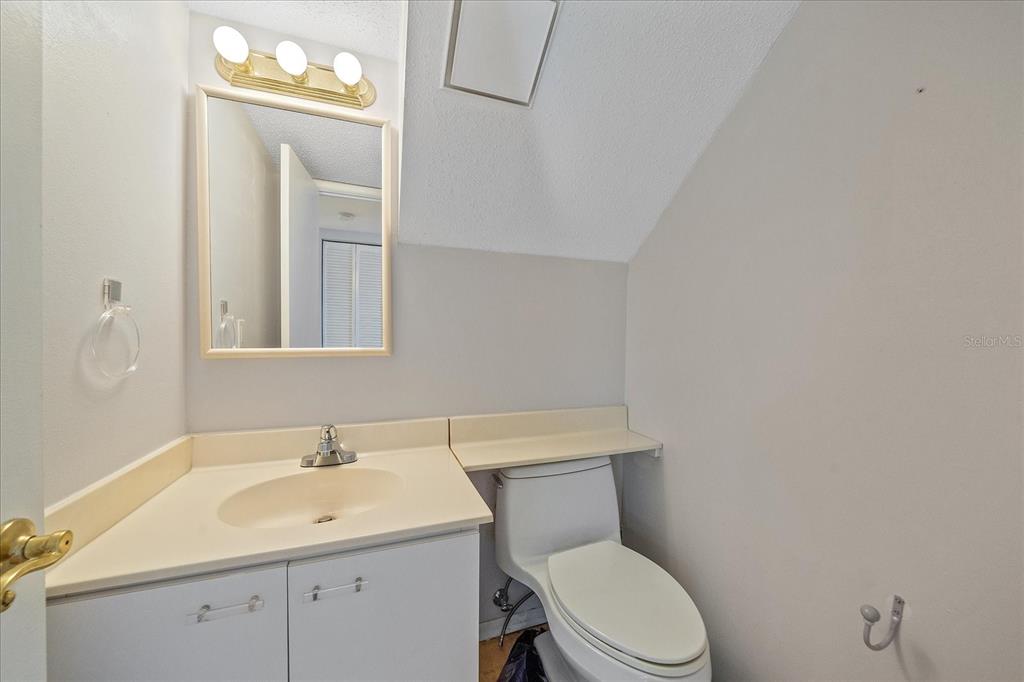 6157 Midnight Pass Road, Unit B12 Sarasota, FL 34242 - Photo 9 of 75 a bathroom with a toilet a sink a vanity and mirror