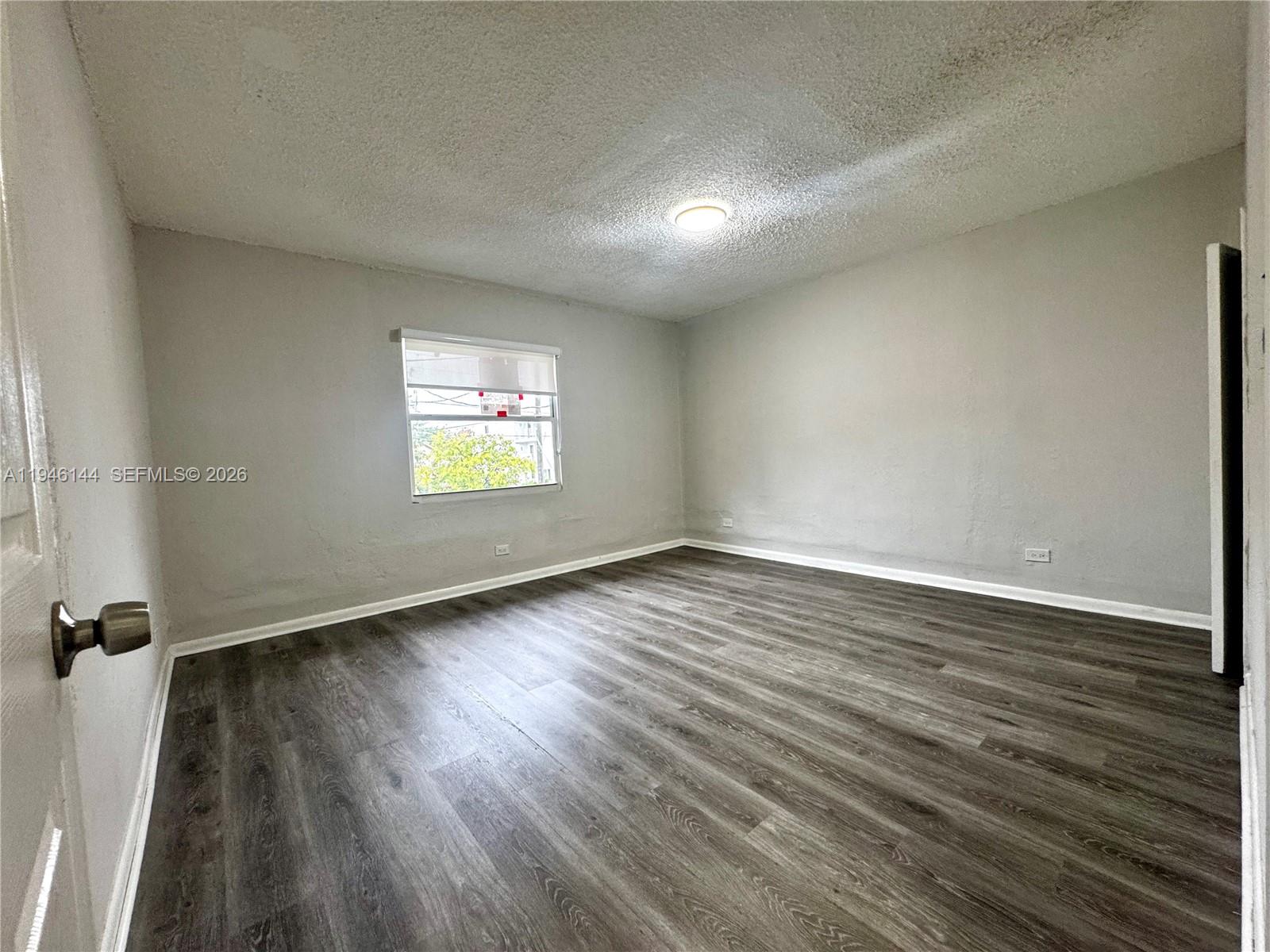 529 Southwest 3rd Street, Unit 2 Miami, FL 33130 - Photo 5 of 10 an empty room with wooden floor and windows
