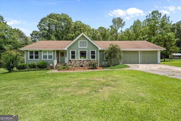 a front view of a house with a garden
