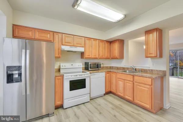 a kitchen with stainless steel appliances granite countertop a refrigerator sink and cabinets