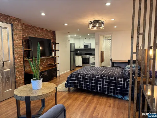 a living room with furniture a flat screen tv and kitchen view