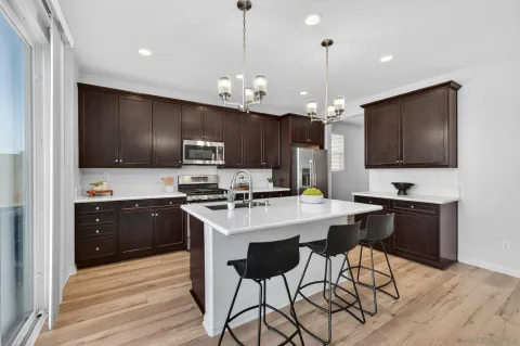 a kitchen with stainless steel appliances a stove a sink refrigerator and a microwave