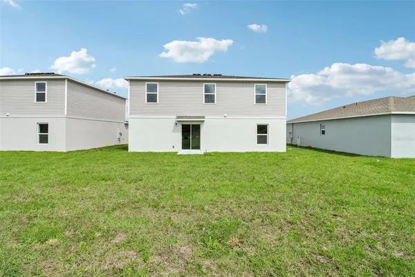 a big white house with a big yard and large trees