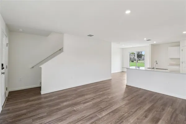 a large white kitchen with wooden floors and a fireplace