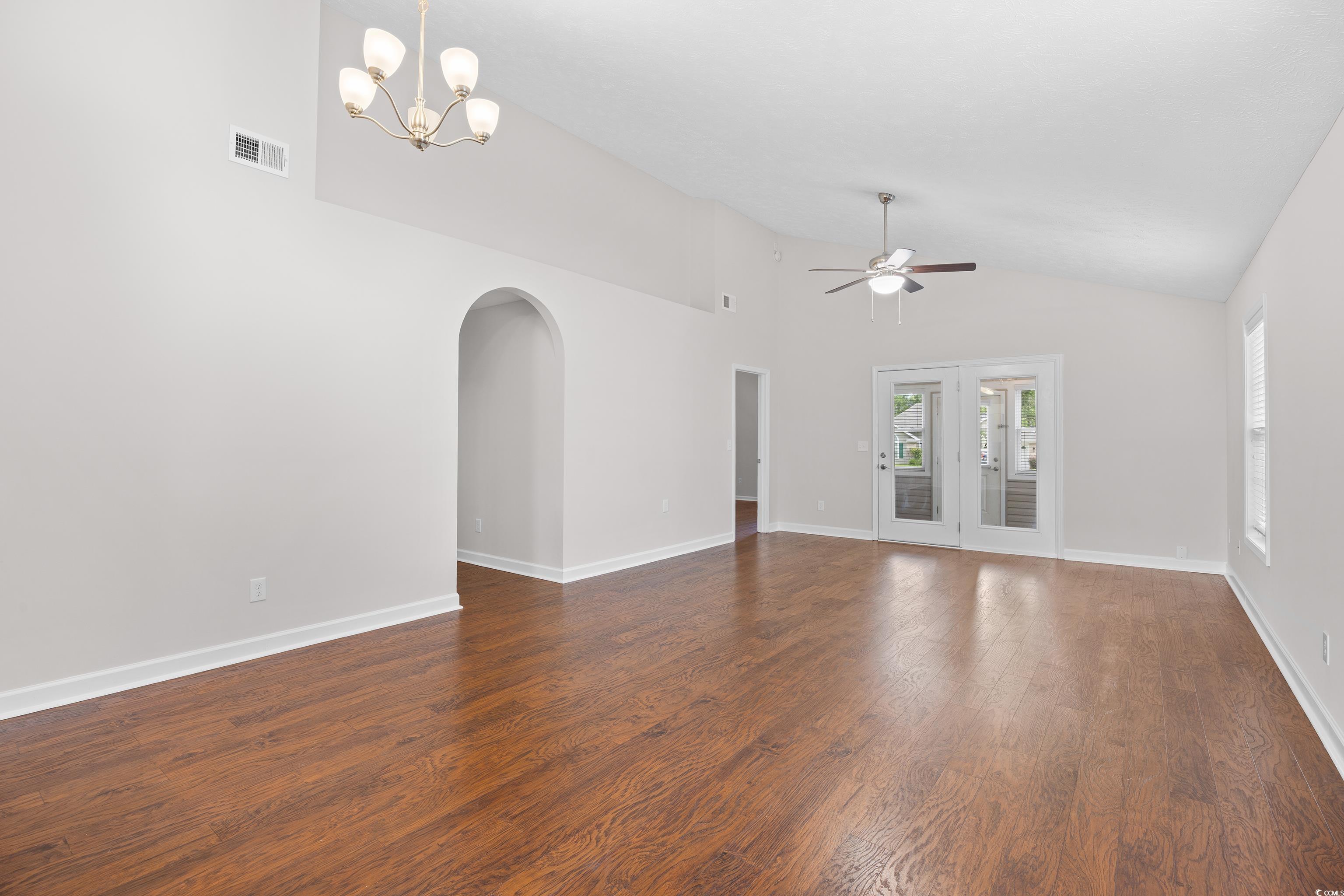 596 Oakmont Drive Myrtle Beach, SC 29579 - Photo 12 of 40 Unfurnished living room with arched walkways, ceiling fan, a chandelier, dark wood-style flooring, and high vaulted ceiling