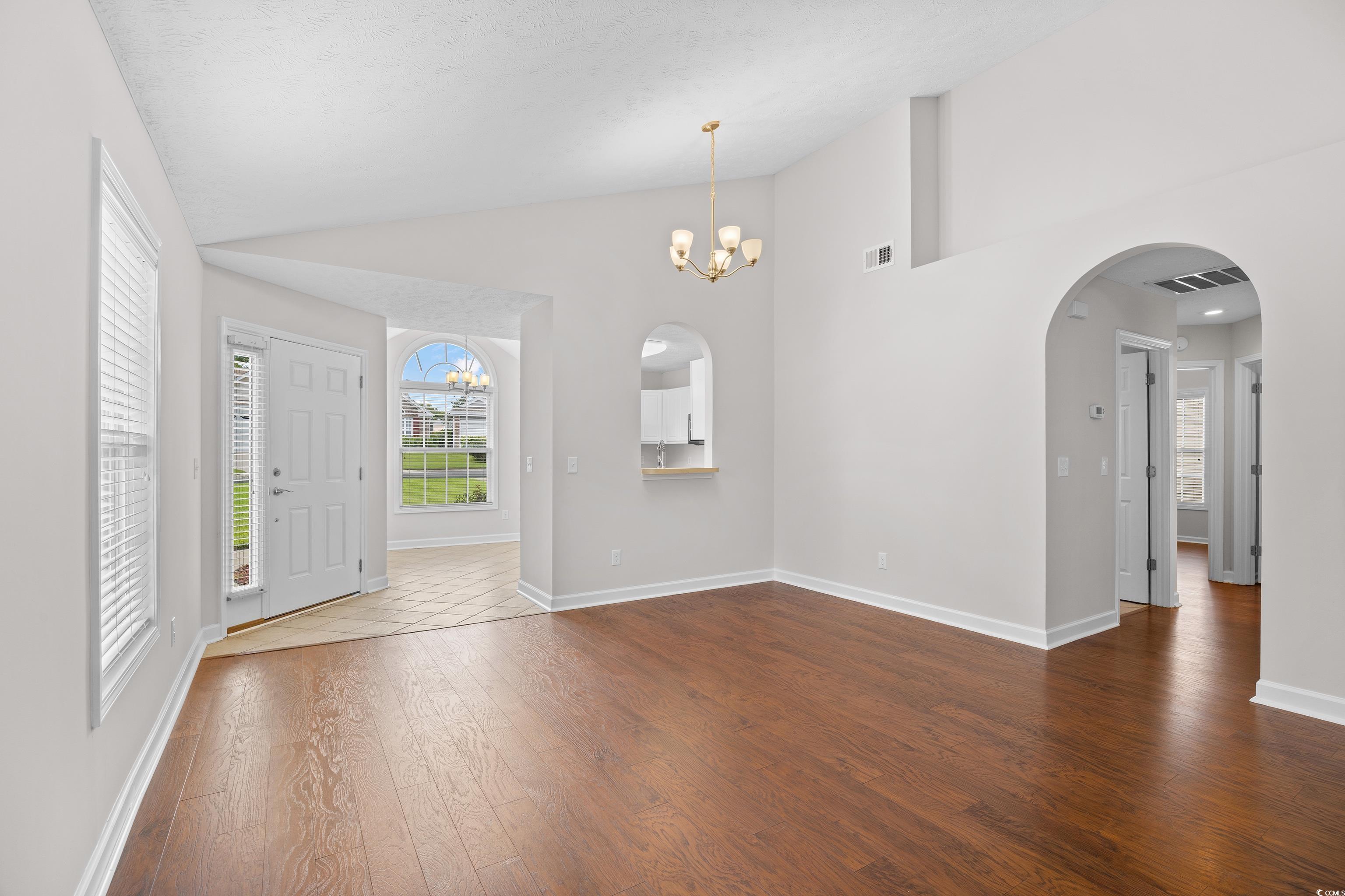 596 Oakmont Drive Myrtle Beach, SC 29579 - Photo 13 of 40 Entrance foyer featuring dark wood-type flooring, a chandelier, arched walkways, and high vaulted ceiling