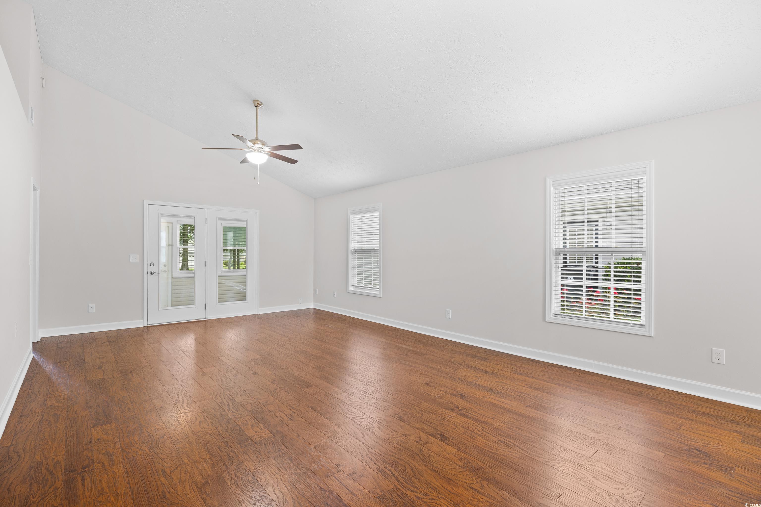 596 Oakmont Drive Myrtle Beach, SC 29579 - Photo 15 of 40 Empty room with a ceiling fan, dark wood-style flooring, and vaulted ceiling