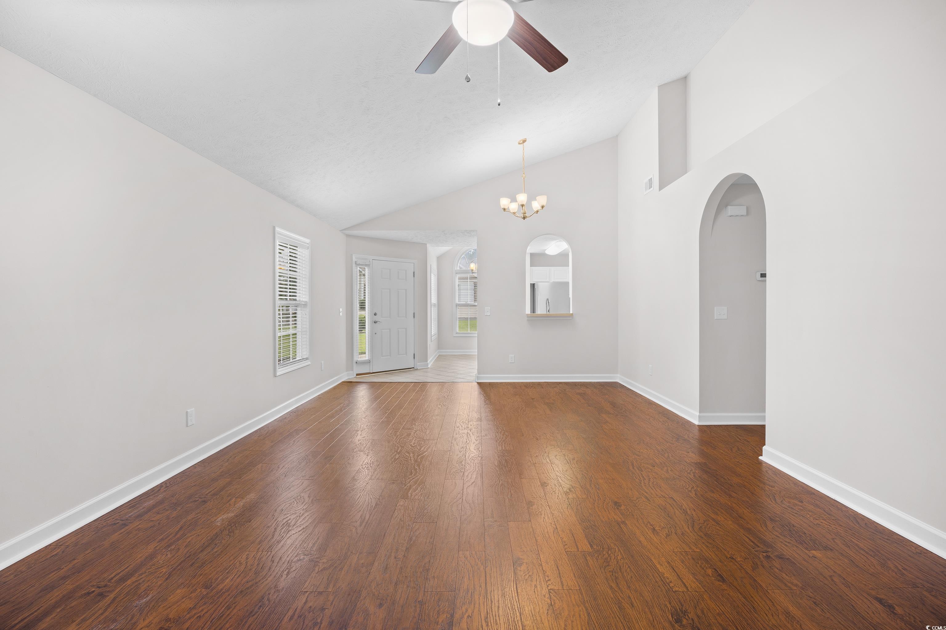 596 Oakmont Drive Myrtle Beach, SC 29579 - Photo 17 of 40 Spare room with ceiling fan, arched walkways, wood finished floors, a chandelier, and high vaulted ceiling