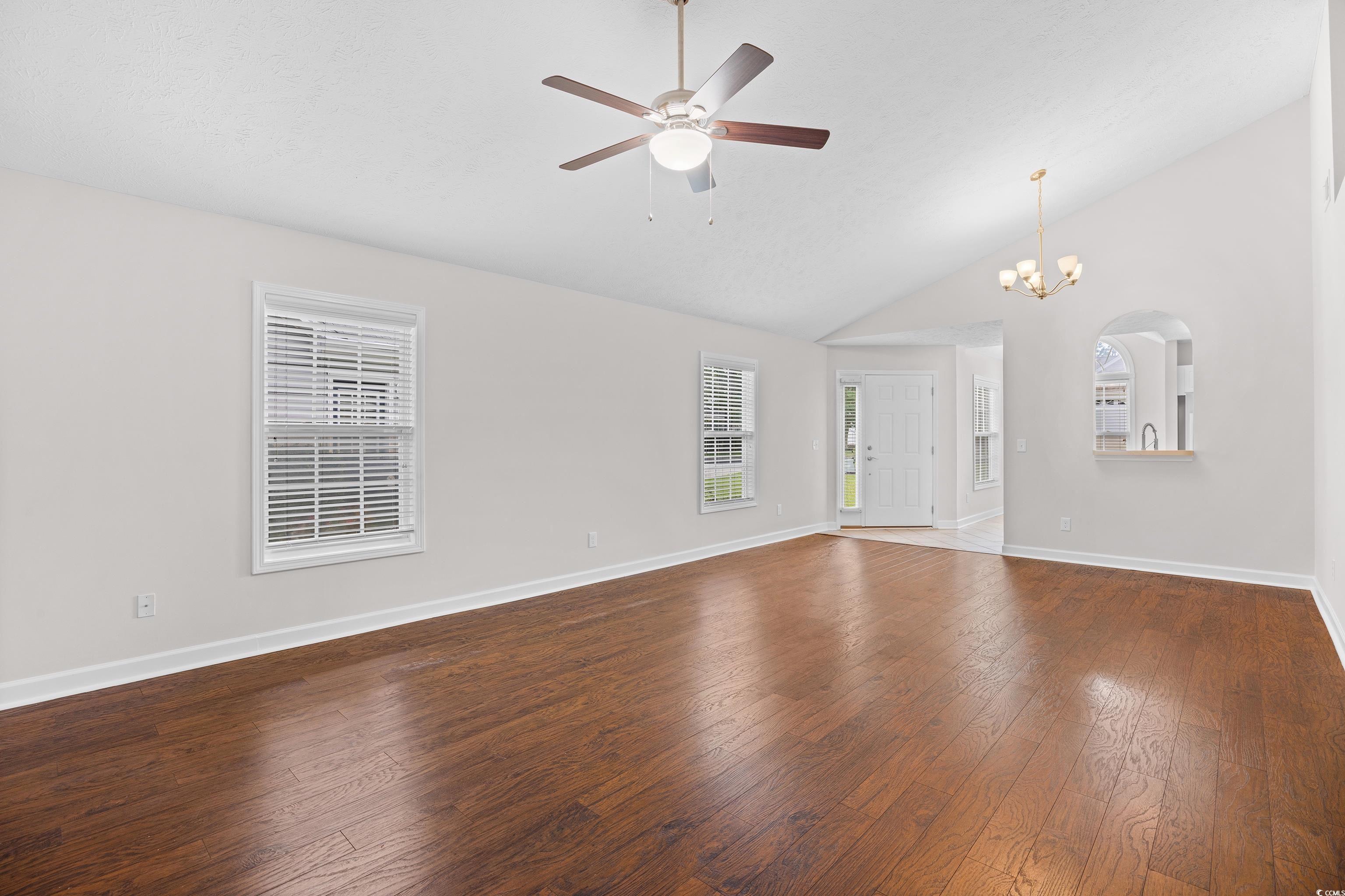 596 Oakmont Drive Myrtle Beach, SC 29579 - Photo 18 of 40 Unfurnished living room featuring a chandelier, hardwood / wood-style floors, ceiling fan, and high vaulted ceiling