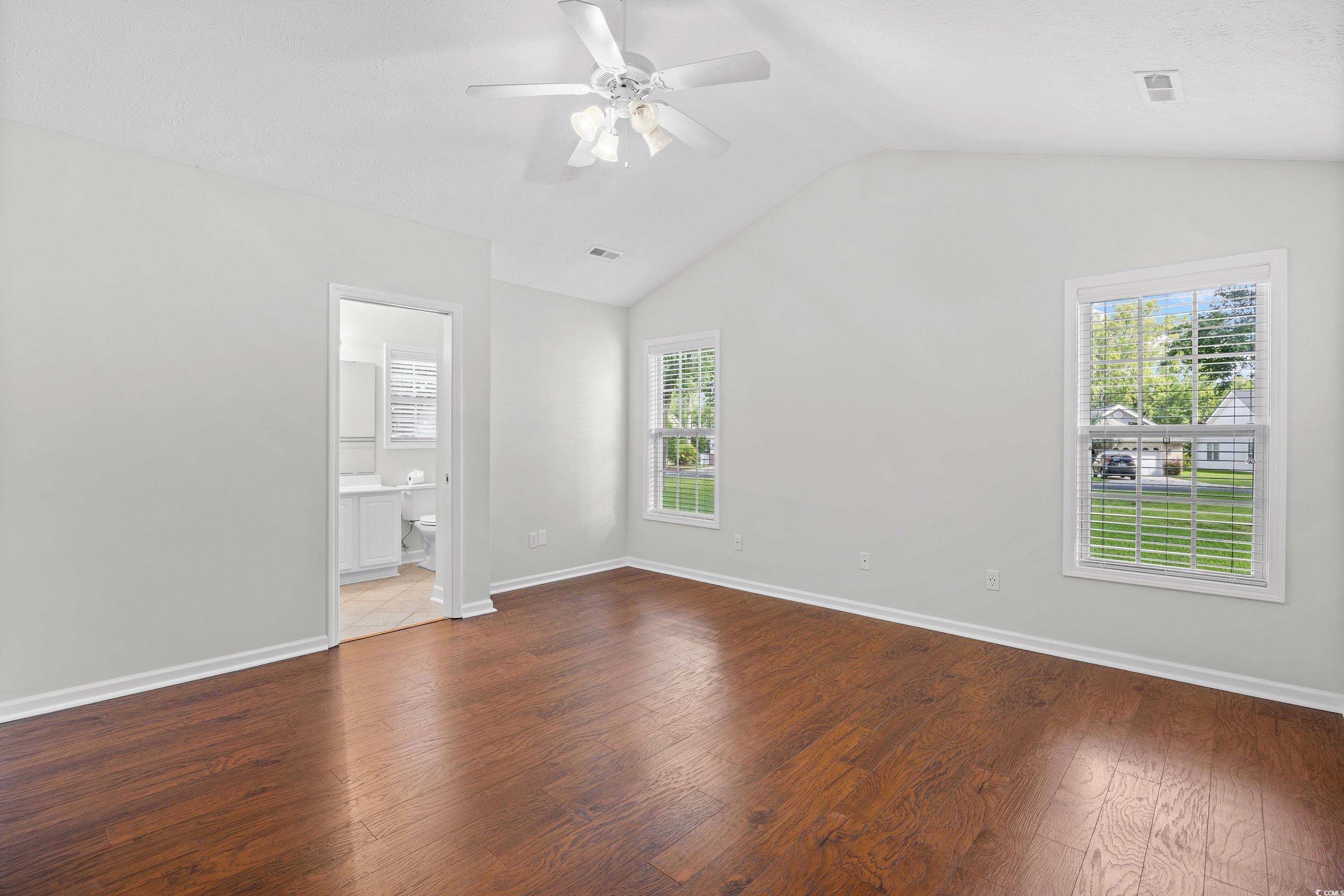 596 Oakmont Drive Myrtle Beach, SC 29579 - Photo 19 of 40 Empty room featuring healthy amount of natural light, lofted ceiling, wood finished floors, and a ceiling fan