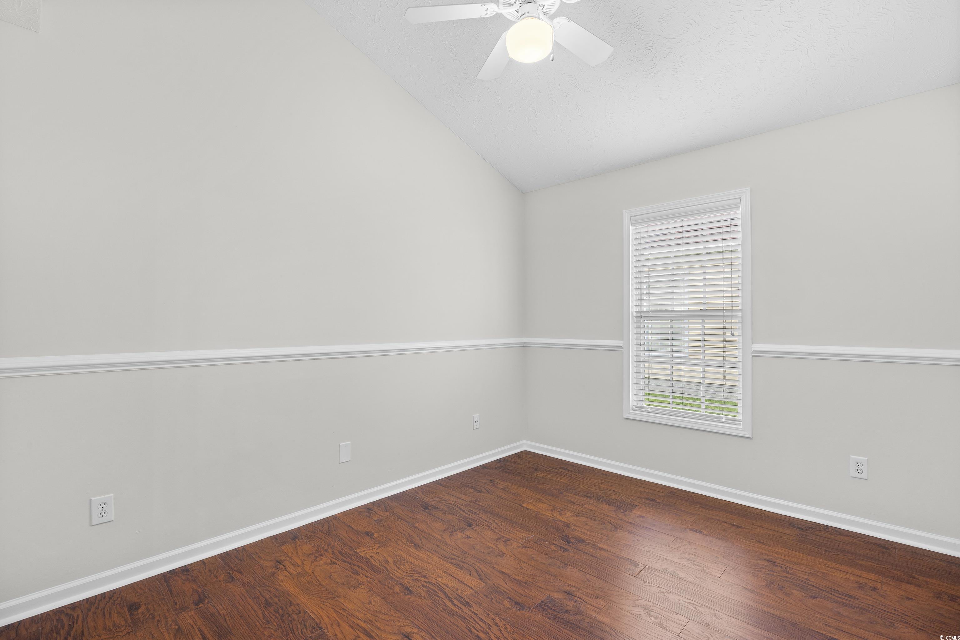 596 Oakmont Drive Myrtle Beach, SC 29579 - Photo 24 of 40 Unfurnished room featuring vaulted ceiling, wood finished floors, and a ceiling fan