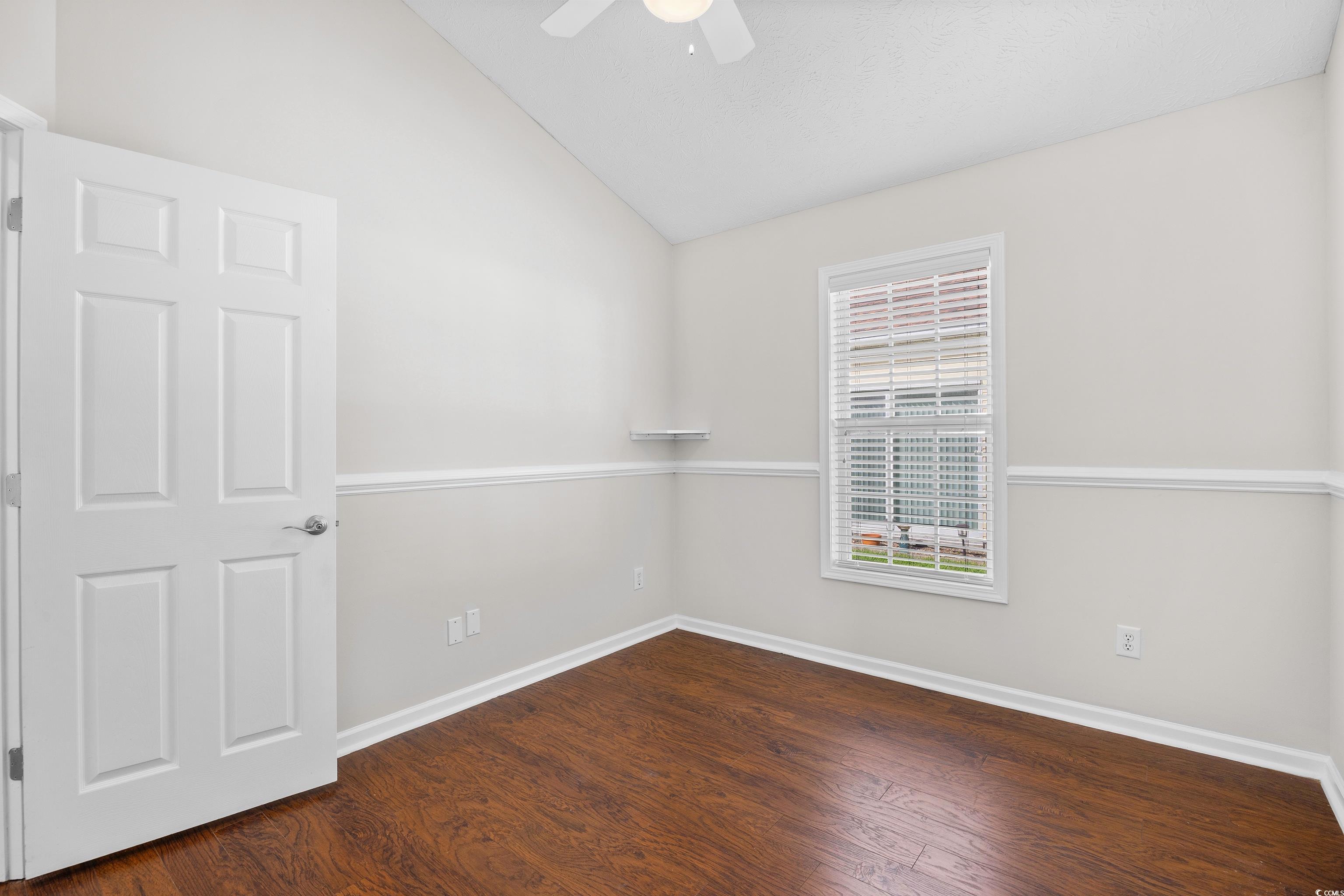 596 Oakmont Drive Myrtle Beach, SC 29579 - Photo 28 of 40 Empty room featuring lofted ceiling, ceiling fan, and wood finished floors