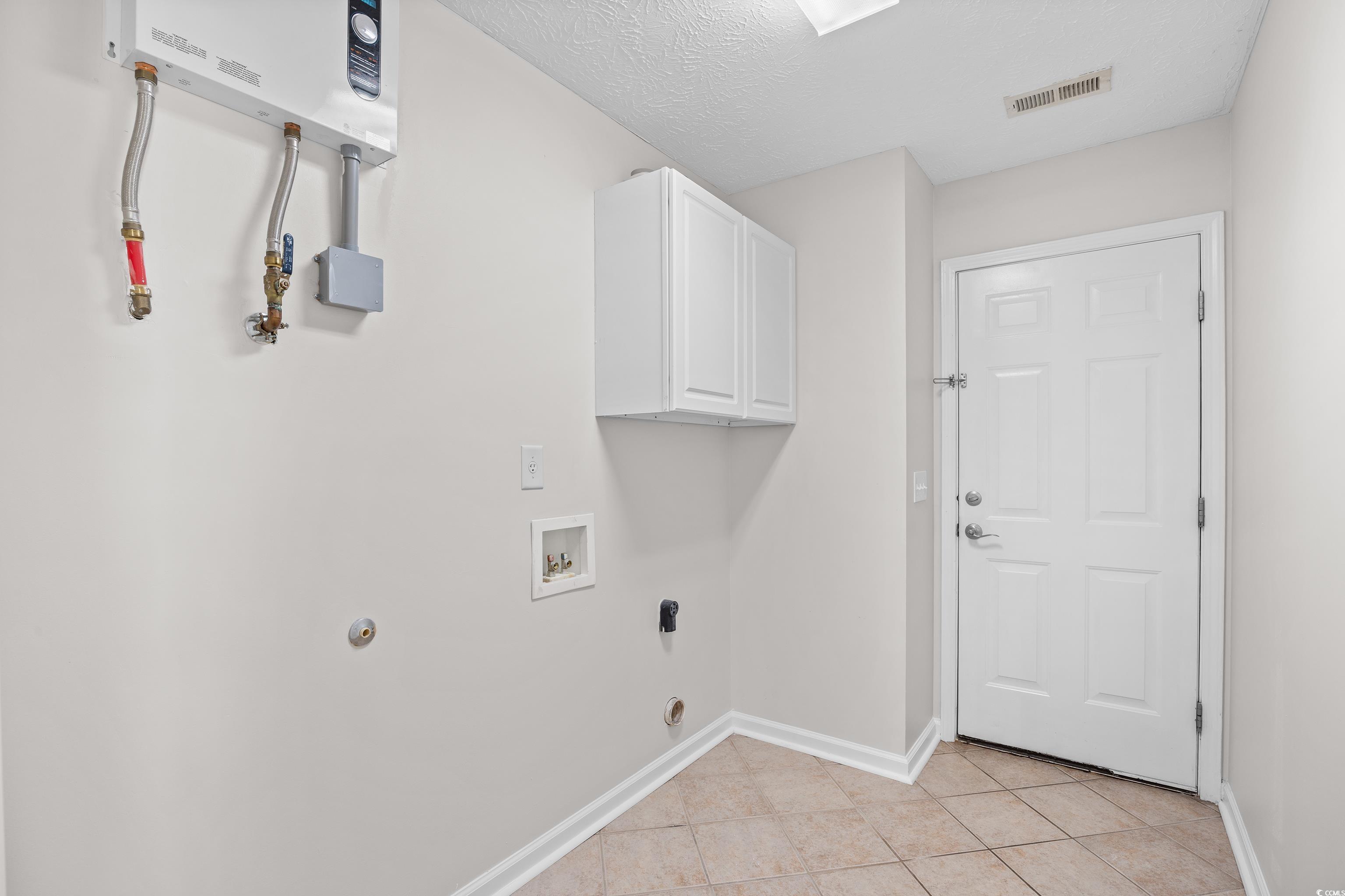 596 Oakmont Drive Myrtle Beach, SC 29579 - Photo 31 of 40 Washroom with hookup for a washing machine, cabinet space, light tile patterned floors, and water heater