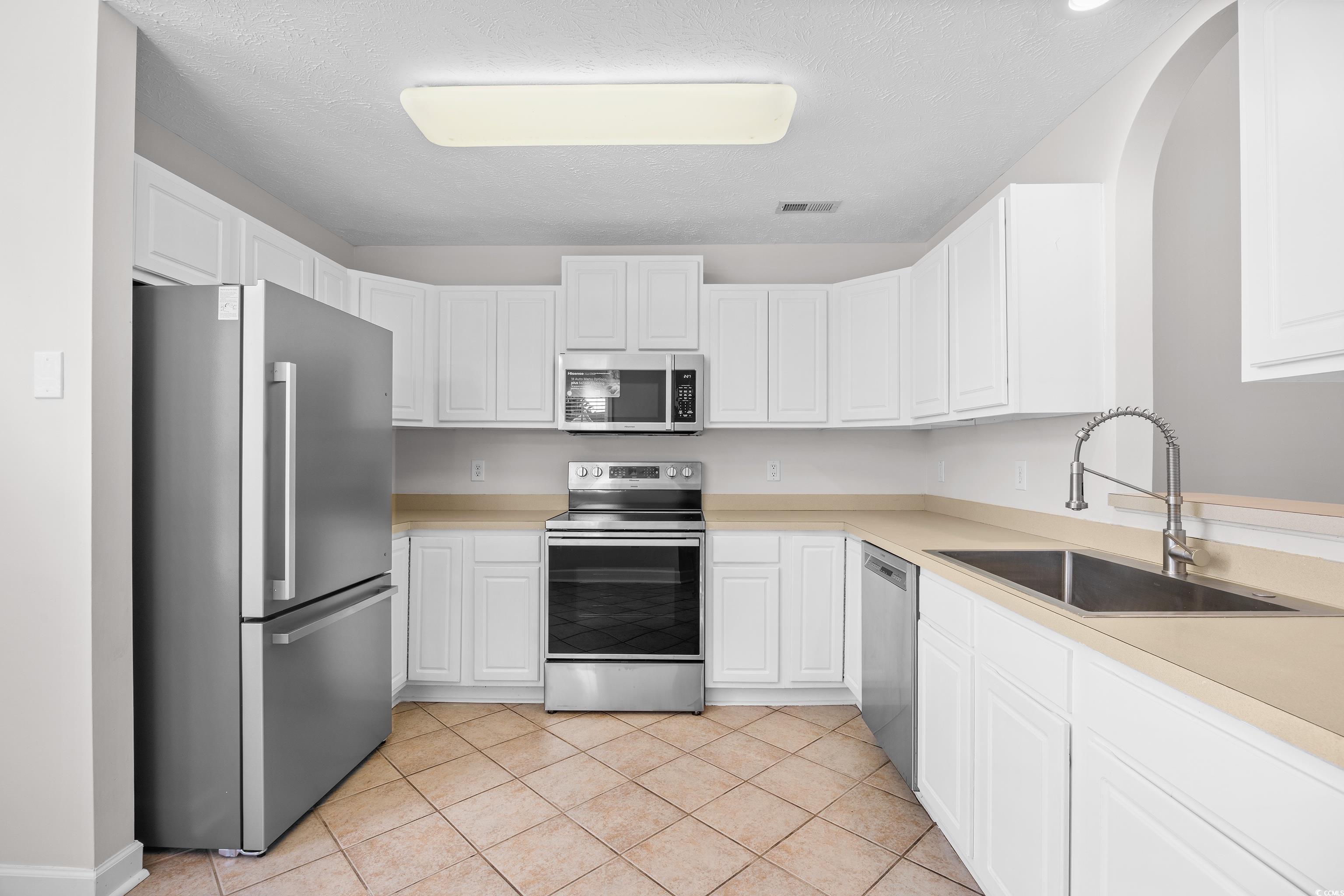596 Oakmont Drive Myrtle Beach, SC 29579 - Photo 8 of 40 Kitchen with appliances with stainless steel finishes, white cabinetry, and light countertops