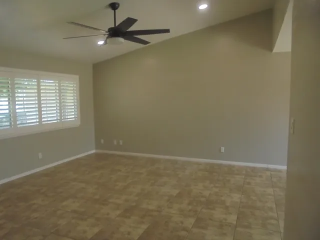 an empty room with a window and a fan