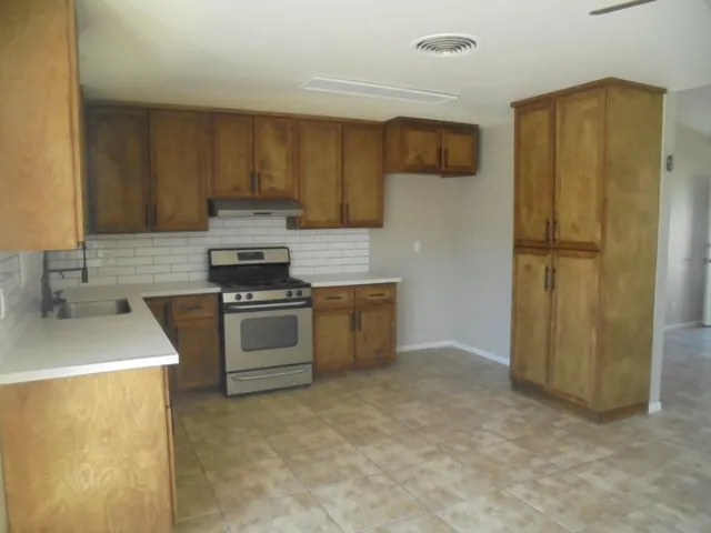 a kitchen with a refrigerator sink and cabinets