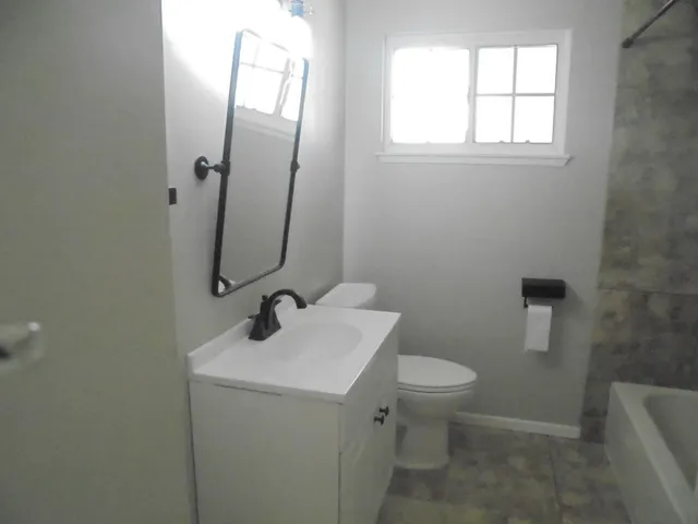 a bathroom with a toilet sink and mirror