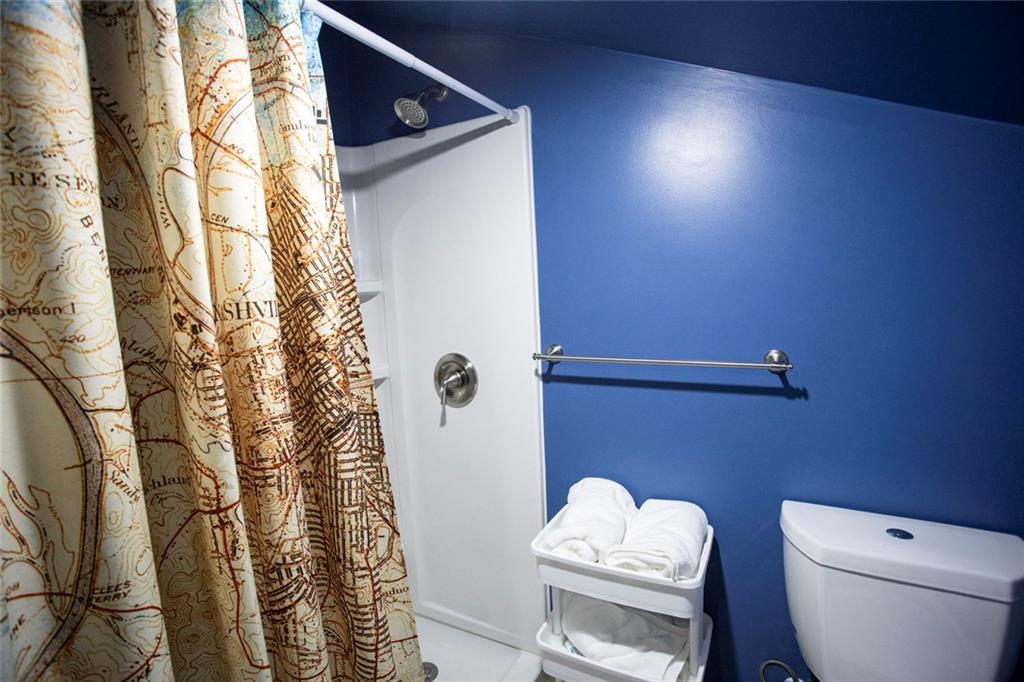 306 Old Gettysburg Way Dallas, GA 30157 - Photo 37 of 44 a white toilet sitting next to a shower curtain