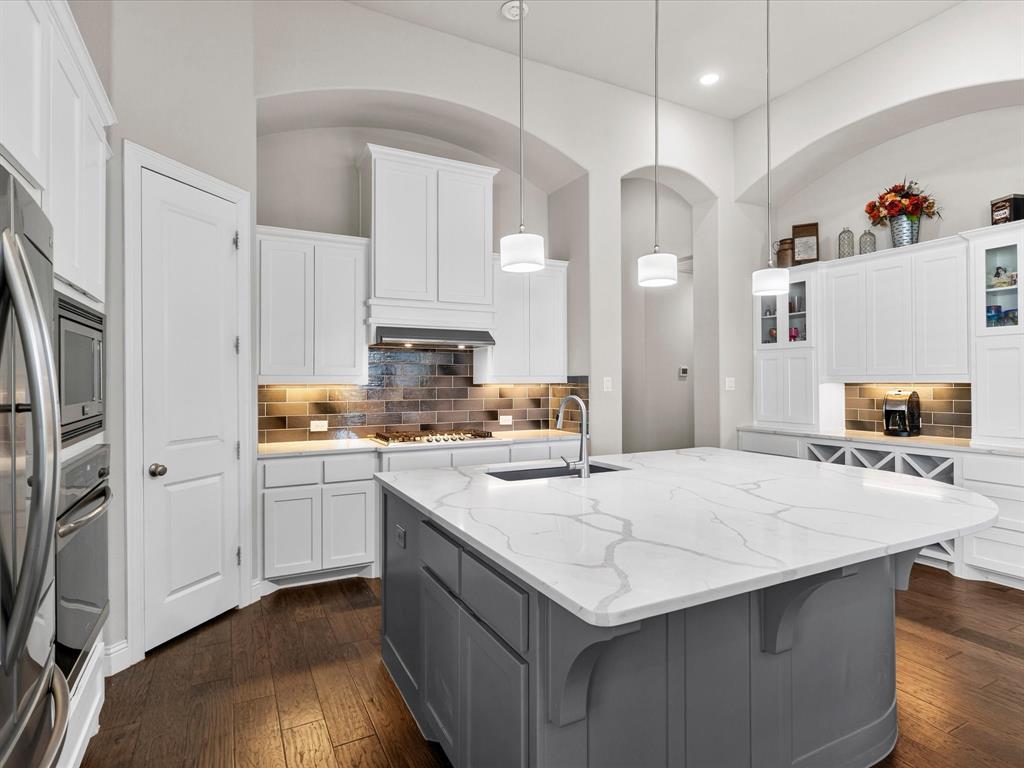 1630 Pebblebrook Lane Prosper, TX 75078 - Photo 17 of 40 a kitchen with stainless steel appliances a stove refrigerator sink and cabinets