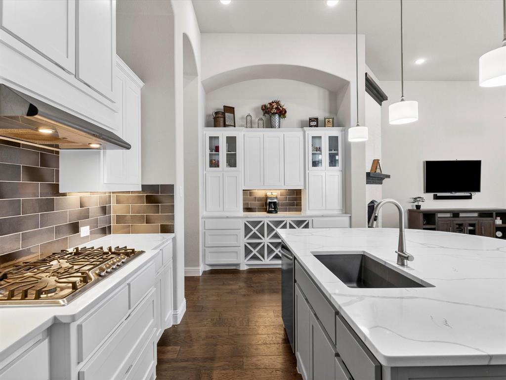 1630 Pebblebrook Lane Prosper, TX 75078 - Photo 18 of 40 a kitchen with a stove a sink and a refrigerator