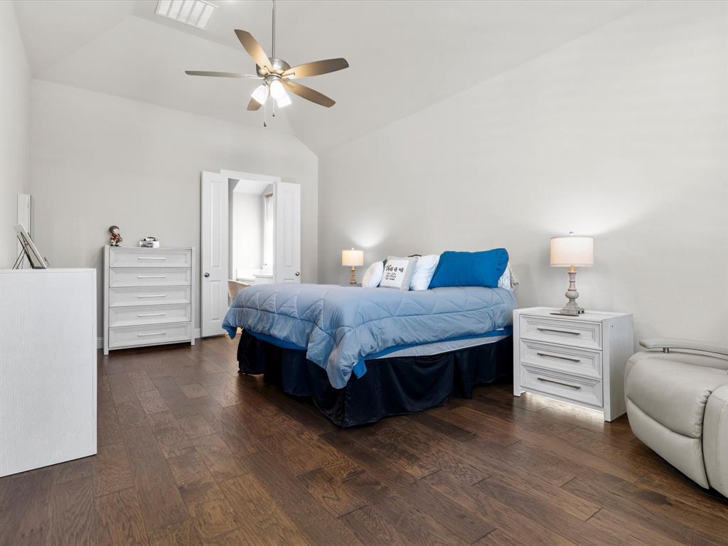 1630 Pebblebrook Lane Prosper, TX 75078 - Photo 26 of 40 a bedroom with a bed and a chandelier