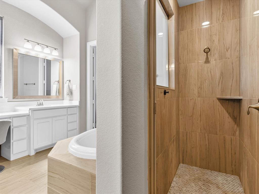 1630 Pebblebrook Lane Prosper, TX 75078 - Photo 30 of 40 a bathroom with a sink and mirror with bathtub