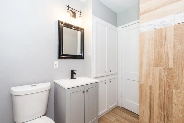a bathroom with a toilet sink and mirror