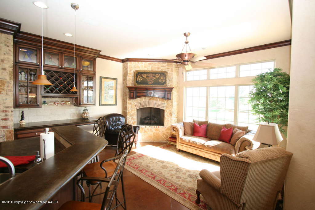 9000 Blackhawk Road Amarillo, TX 79119 - Photo 11 of 39 a living room with furniture a fireplace and a floor to ceiling window