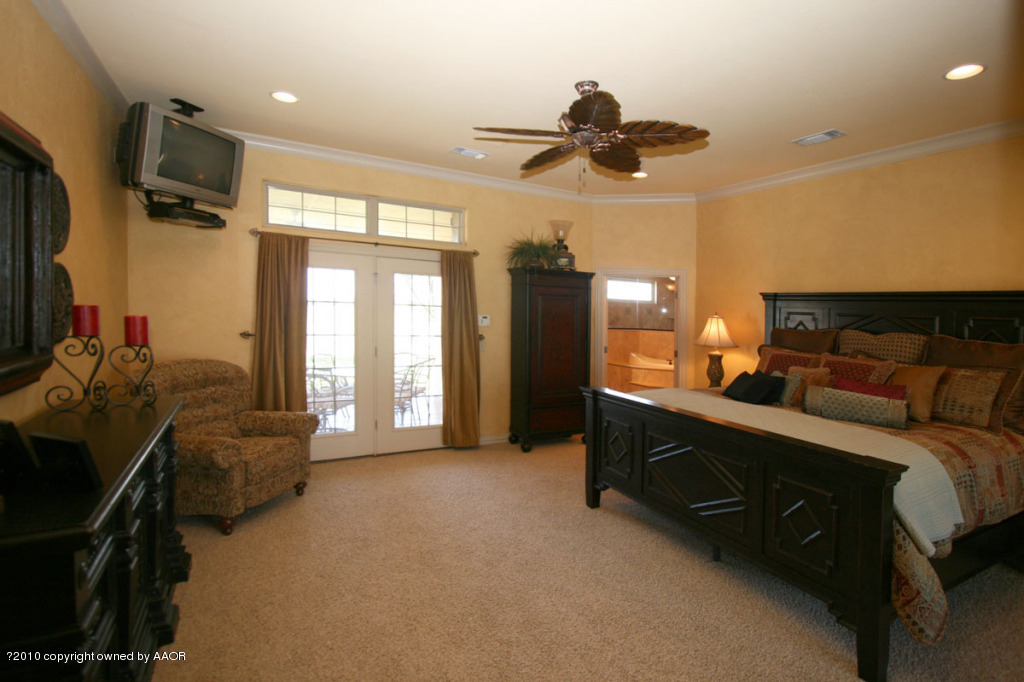 9000 Blackhawk Road Amarillo, TX 79119 - Photo 13 of 39 a spacious bedroom with a bed and a chandelier