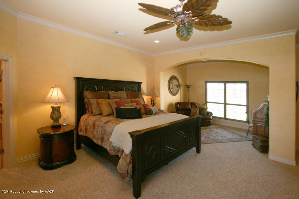 9000 Blackhawk Road Amarillo, TX 79119 - Photo 15 of 39 a bedroom with a bed and a chandelier
