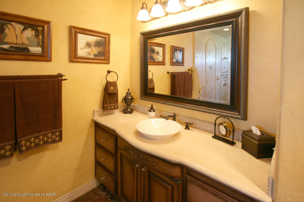 9000 Blackhawk Road Amarillo, TX 79119 - Photo 17 of 39 a bathroom with a sink and a mirror
