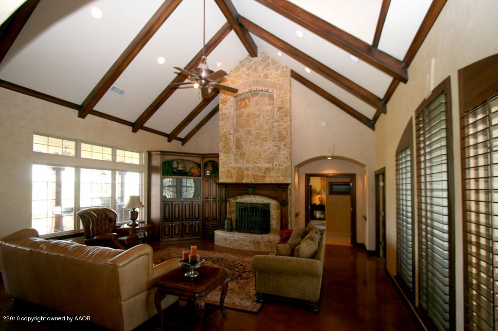 9000 Blackhawk Road Amarillo, TX 79119 - Photo 3 of 39 a living room with furniture a fireplace and a floor to ceiling window