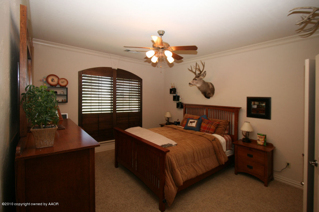 9000 Blackhawk Road Amarillo, TX 79119 - Photo 23 of 39 a bedroom with a bed and a chandelier