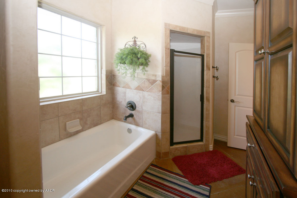 9000 Blackhawk Road Amarillo, TX 79119 - Photo 24 of 39 a bathroom with a tub a sink and a shower