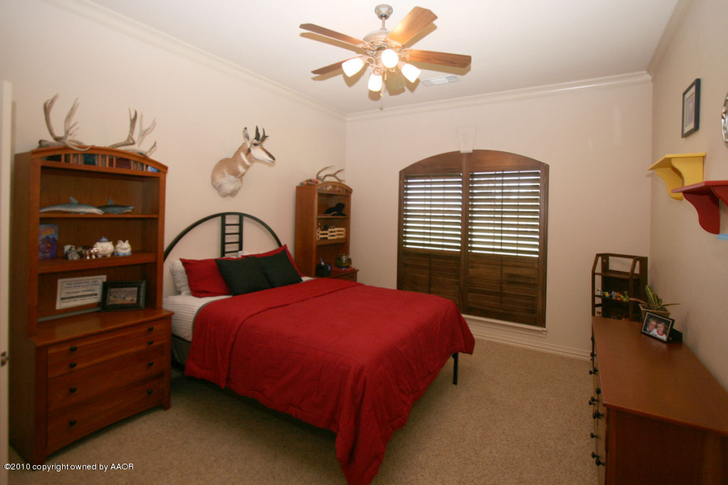 9000 Blackhawk Road Amarillo, TX 79119 - Photo 25 of 39 a bedroom with a bed and a chandelier