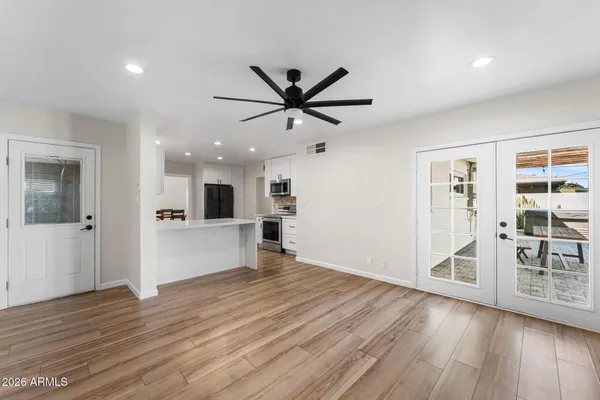 a view of an empty room with window and wooden floor