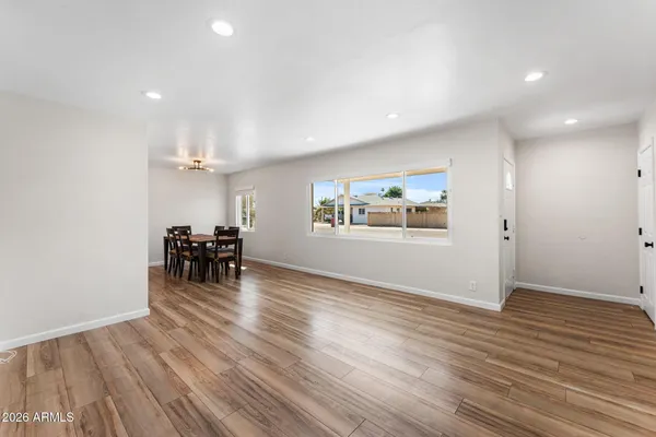 an empty room with wooden floor furniture and windows