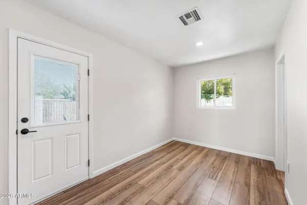 an empty room with wooden floor and a window