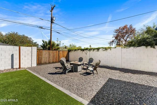 a view of a chairs and fire pit in backyard of the house