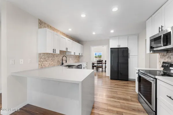 a kitchen with stainless steel appliances a refrigerator stove microwave and cabinets