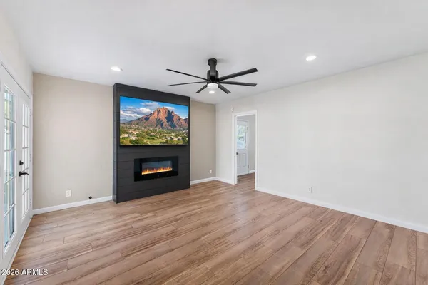 a view of an empty room with a fireplace and a window