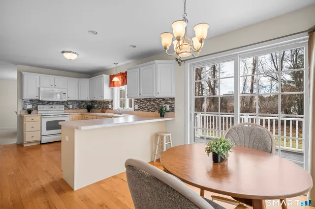 a kitchen with stainless steel appliances granite countertop a stove a kitchen island a window and a dining table