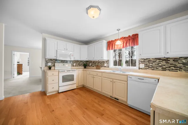 a kitchen with granite countertop white cabinets and white appliances