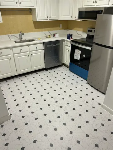 a kitchen with a sink a stove a refrigerator and cabinets