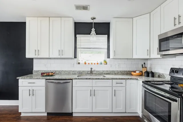 a kitchen with white cabinets and appliances